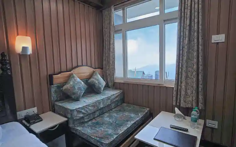 Cozy seating area with mountain view at Sher Bengal Darjeeling hotel room