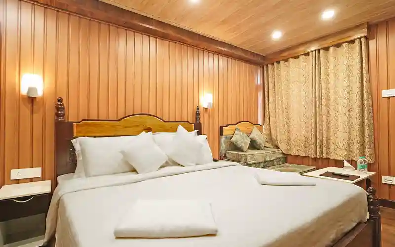 Luxury bedroom at eco-friendly hotels in Darjeeling with wooden walls and soft lighting